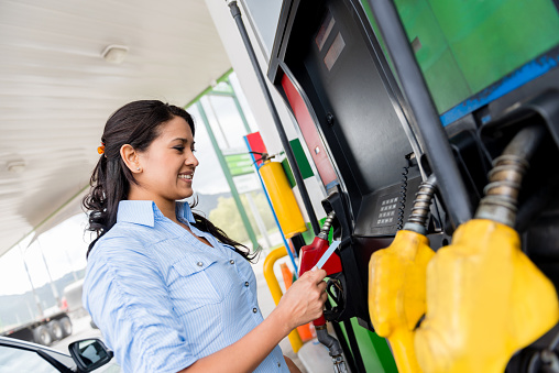 Woman at the gas station paying with credit card