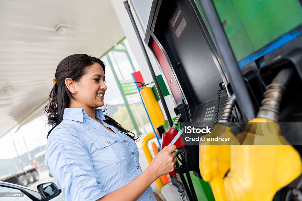 Woman at the gas station Woman at the gas station paying with credit card Gas Station Stock Photo