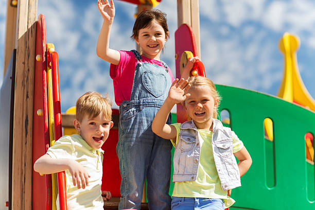 istock group of happy kids waving hands on playground 482802258