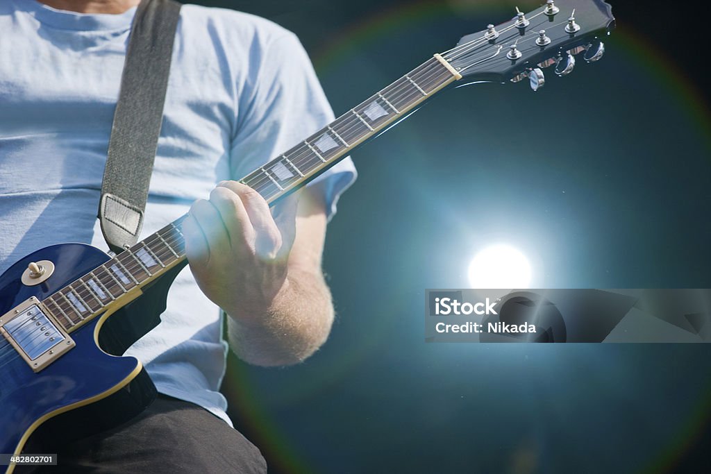 Rock band live guitar player in action on stage Adult Stock Photo
