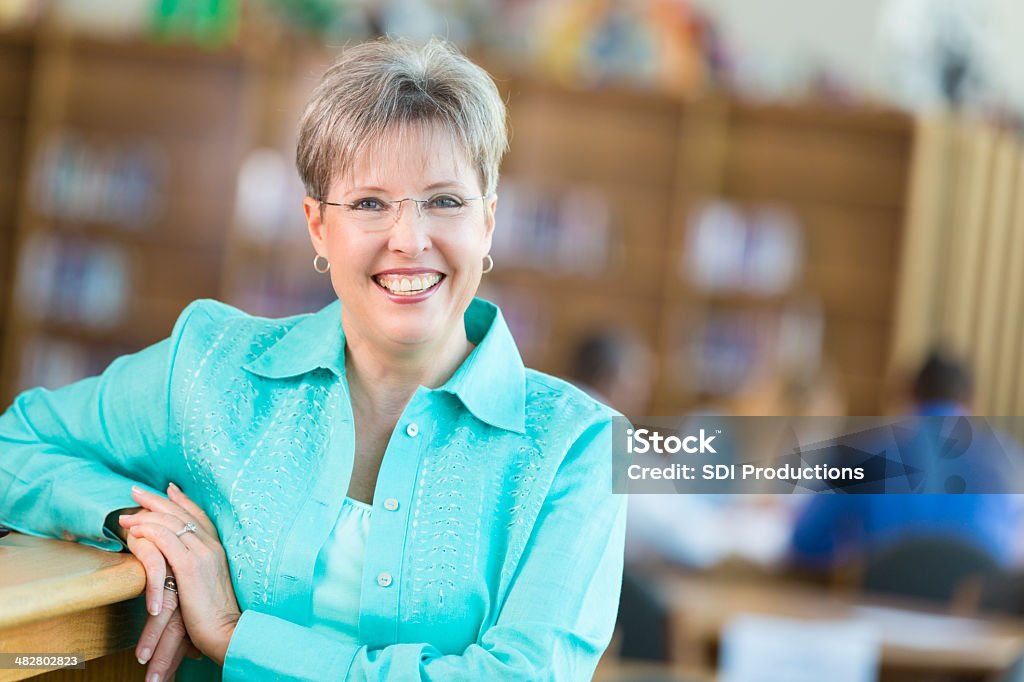 Sênior professor de escola ou executivo na biblioteca - Foto de stock de Colégio - Educação royalty-free