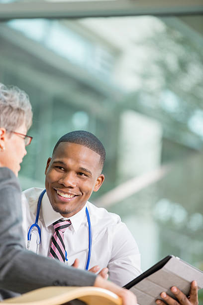 senior patient discutant avec jeune médecin sur résultat d'examen - résultat dexamen photos et images de collection