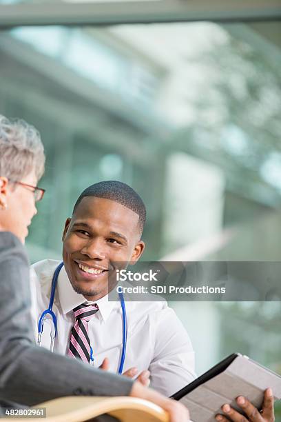 Foto de Sênior Falando Com O Paciente Jovem Médico Sobre O Resultado Do Teste e mais fotos de stock de Doutor