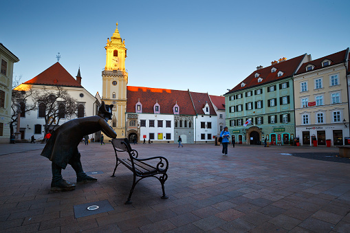 Bratislava, Slovakia - January 05 2015: People in the main square in Bratislava, Slovakia. Old town Hall can be seen in the image together with one of the most recent tourist attractions - statue of napoleonian soldier.