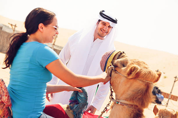 アラビアの男性と観光の乗馬、ラクダ - united arab emirates middle eastern ethnicity men camel ストックフォトと画像