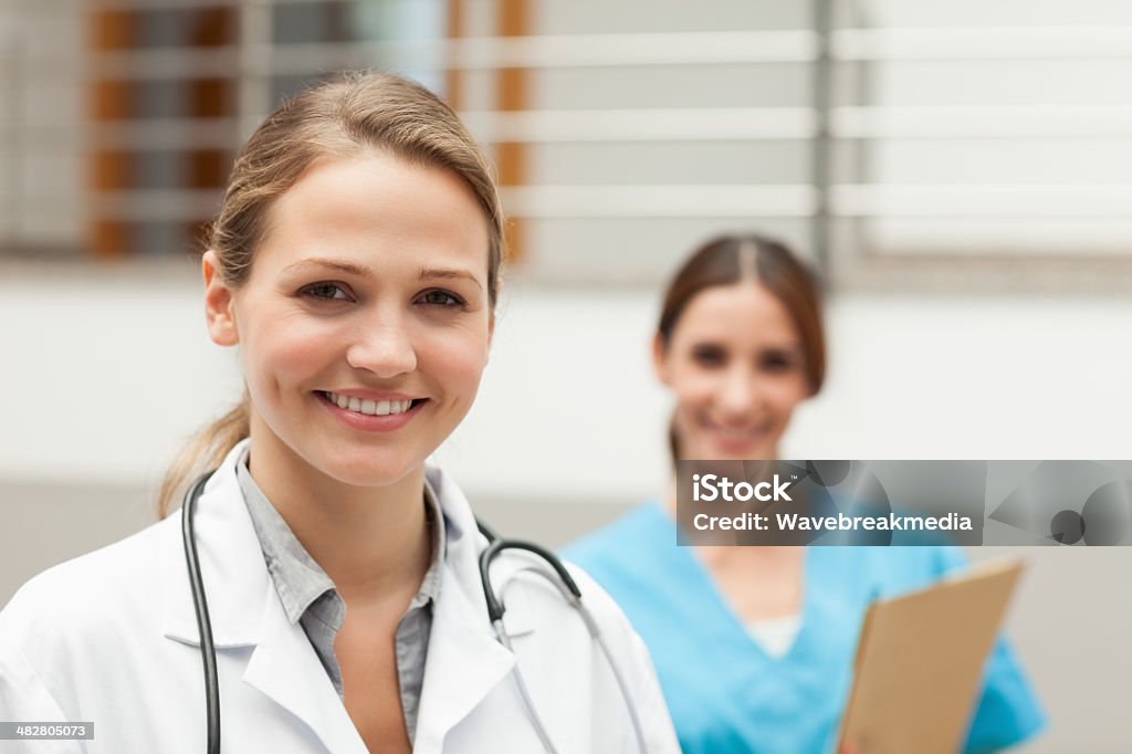 Doctor and nurse standing Doctor and nurse standing in a hospital reception Horizontal Stock Photo
