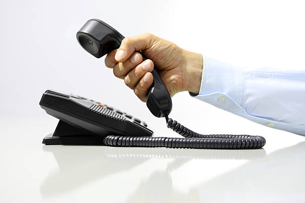 istock hand with office phone on desk 482805078