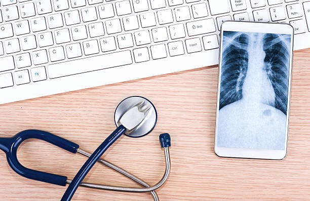 telehealth: 스마트폰을 청진기 및 키보드 - digital tablet doctor note pad x ray image 뉴스 사진 이미지