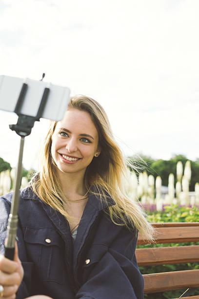 istock Young Beautiful Woman Taking Selfies In A Park 482809648