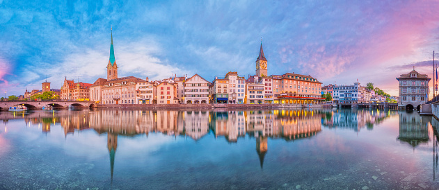 Panoramic view on Zurich, the river Limmat, Limmatquai, Fraumünster Church (Women's Minster), St. Peter Church and the landmark town hall at sunrise.