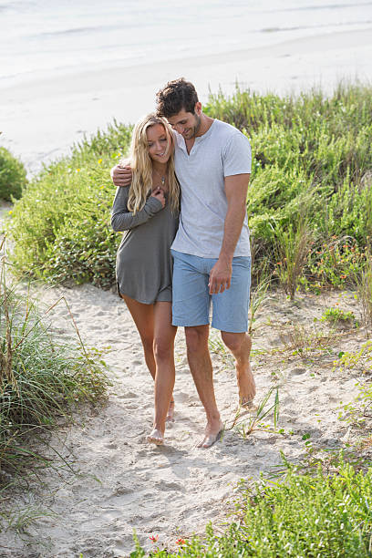 istock Young romantic couple walking on beach 482818758
