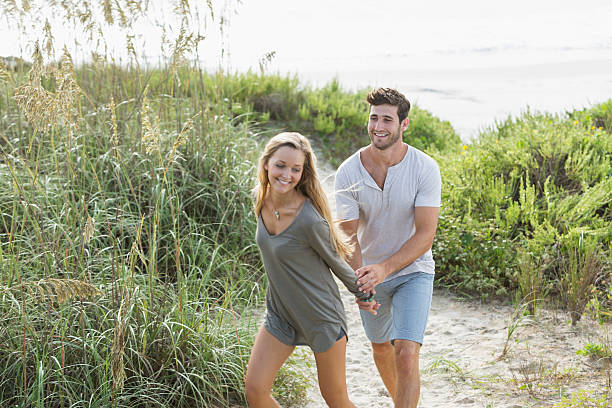 istock Romantic couple walking on sand dunes holding hands 482818762