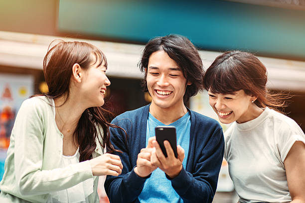 gruppe von jungen mit smartphone japanischen personen - teenager city life laughing group of people stock-fotos und bilder