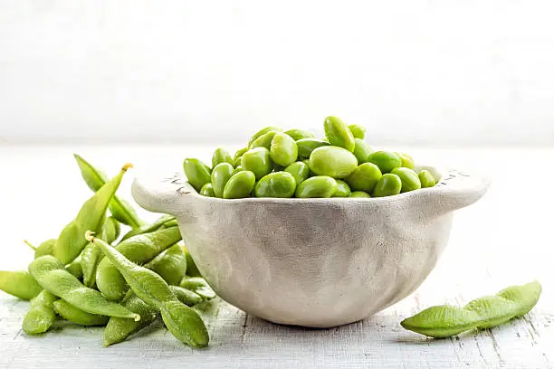 bowl of green beans on white wooden table