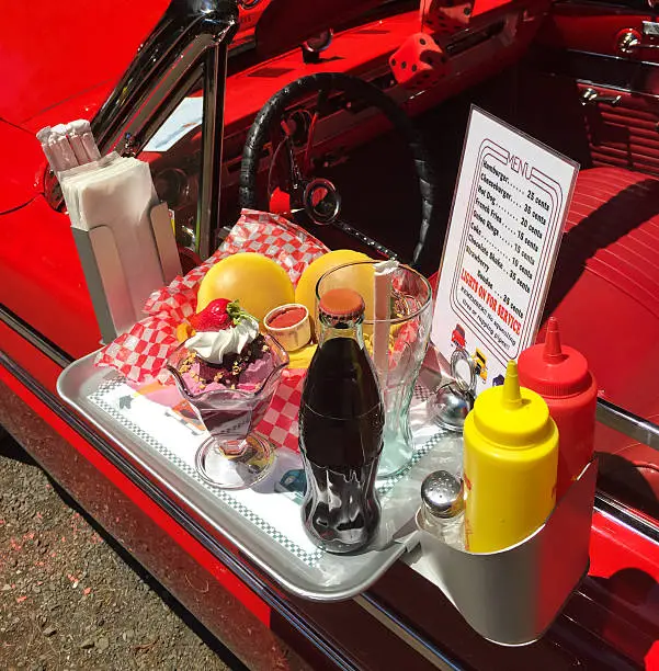 Red car at 1950s Drive-In with food on door