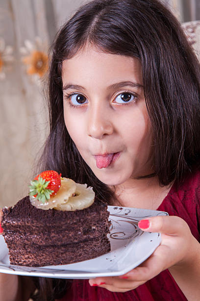 istock smal middle eastern happy girl drinking milk with cake 482829122