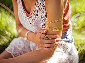 Boho girl with a gold foil temporary arm tattoo