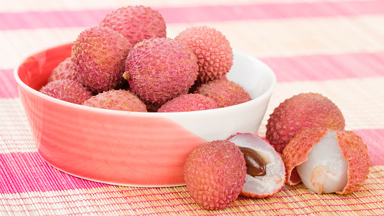 Lychees - Fresh lychees in a pink bowl.