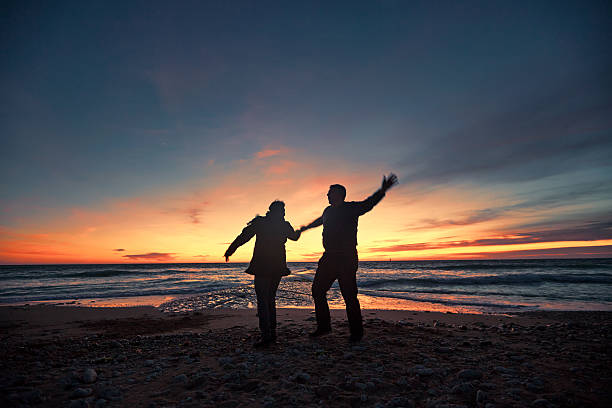 istock Senior couple dancing on seashore at sunset 482832646