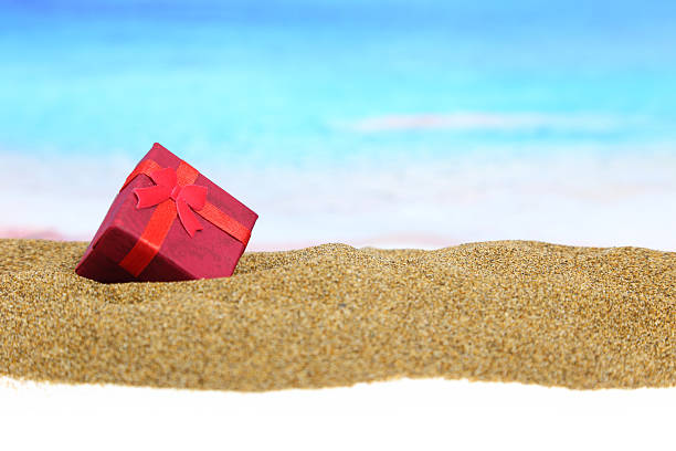 istock Gift box with ribbon on the sand 482834317