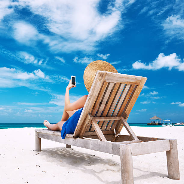 istock Young woman with mobile phone at the beach 482834659