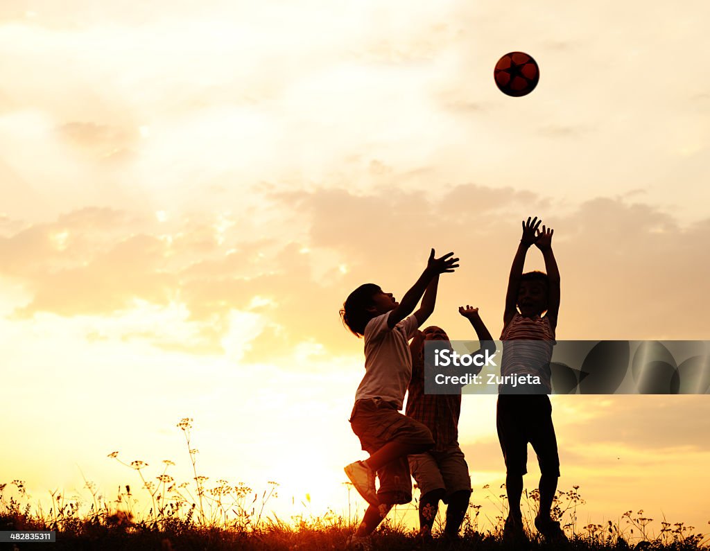Silhouette, group of happy children playing on meadow, sunset, summertime Shadow of many kids playing in nature, sunset, summertime Child Stock Photo