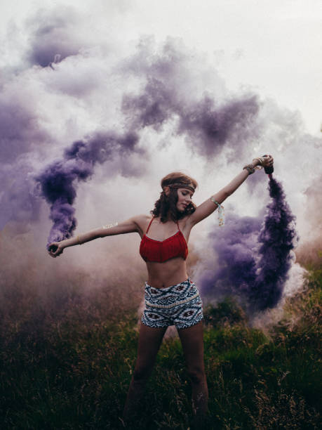 istock Boho girl playing with purple smoke in a park 482837364