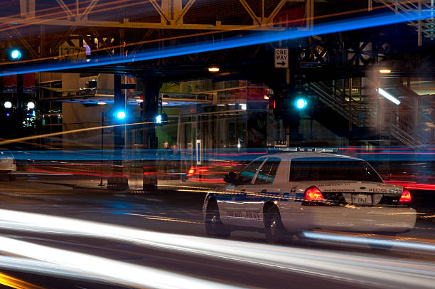 Сhicago, USA - October 28, 2013: A police car sitting in the middle of State Street at night shot with a long exposure to capture passing vehicle lights. 