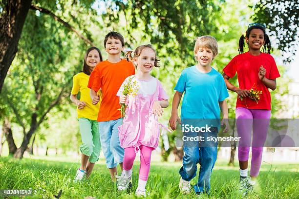 Gruppe Von Kinder Laufen In Der Natur Stockfoto und mehr Bilder von Kind - Kind, Blume, Kindheit