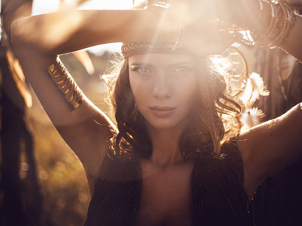Beautiful wild girl portrait in golden sun flare Portrait of a beautiful wild girl standing a summer field in golden afternoon sun flare boho photos stock pictures, royalty-free photos & images