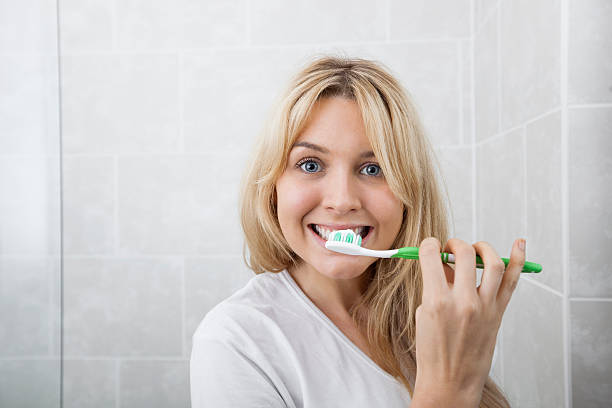 istock Young woman brushing teeth in bathroom 482852199