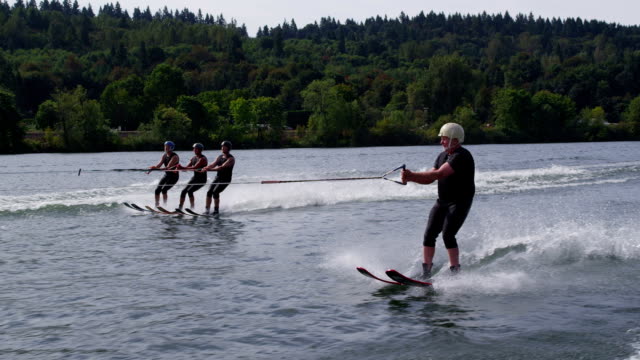 Three water skiers go off jump and one goes under