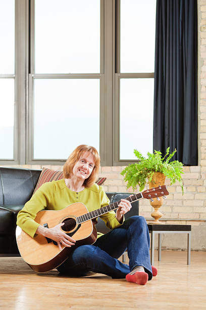 istock Middle Age Woman Playing Guitar in Her Home 482854365
