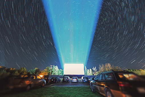 Drive in movie goers enjoy a screening under a canopy of spinning stars.  Long exposure.