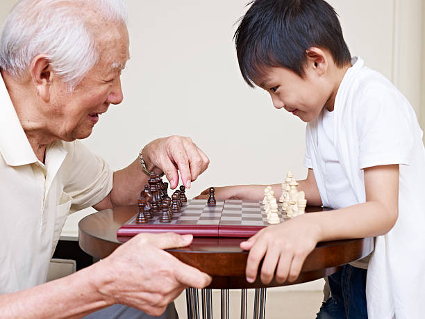 grandpa and grandson asian grandpa and grandson playing chess. click for more: china chinese ethnicity smiling grandparent stock pictures, royalty-free photos & images