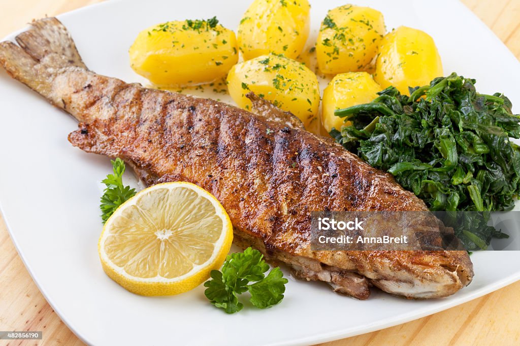 Fried Trout with boiled potatoes and spinach 2015 Stock Photo