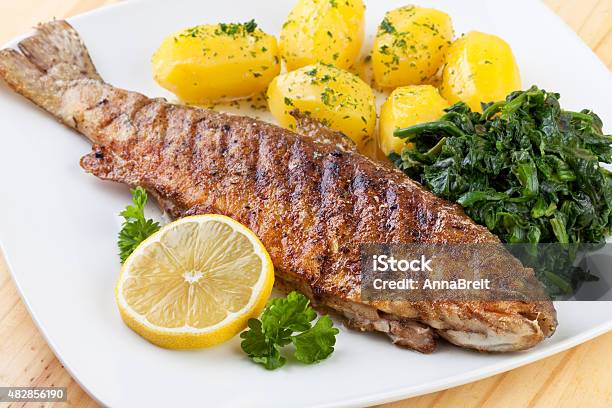 Fried Trout With Boiled Potatoes And Spinach Stock Photo - Download Image Now - 2015, Baked, Butter