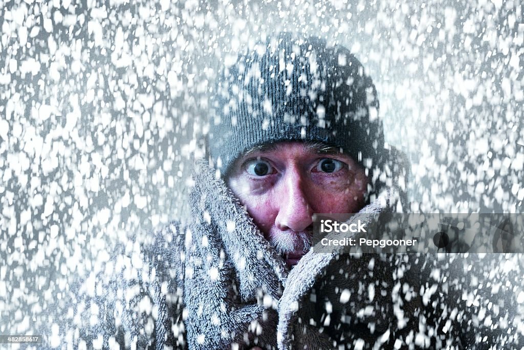 Wintery scene of a man shivering in a snow storm Wintery picture of a very cold man with a XMAS vibe Cold Temperature Stock Photo