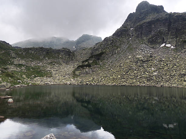 istock Mountain peak reflection in the dark lake waters 482858754