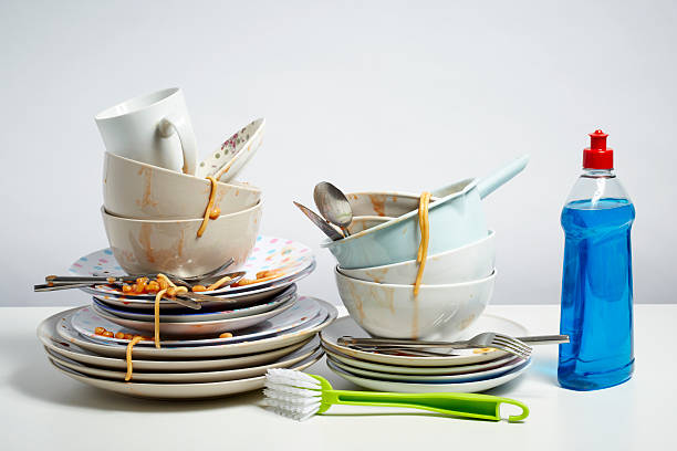 istock Dirty dishes pile needing washing up on white background 482859043