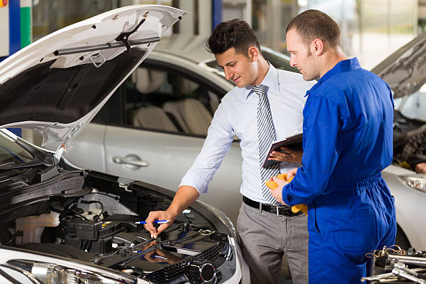 Auto Mechanic and Manager Auto mechanic and technician posing at camera in repair shop. car portrait men expertise stock pictures, royalty-free photos & images