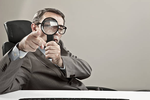 istock Businessman looking through magnifying glass 482865700