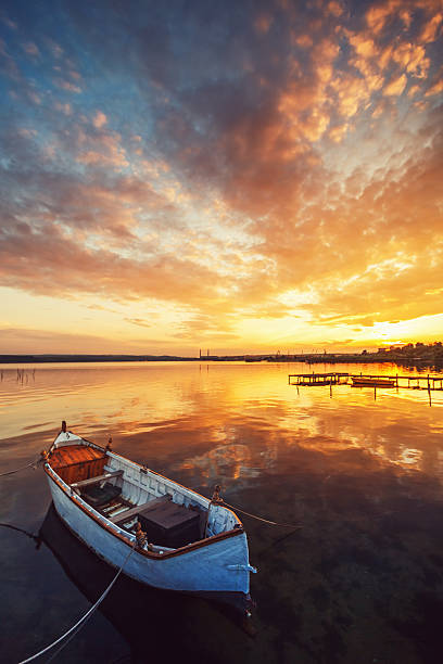 istock Sunset over lake and a boat with sky water reflecting 482871746
