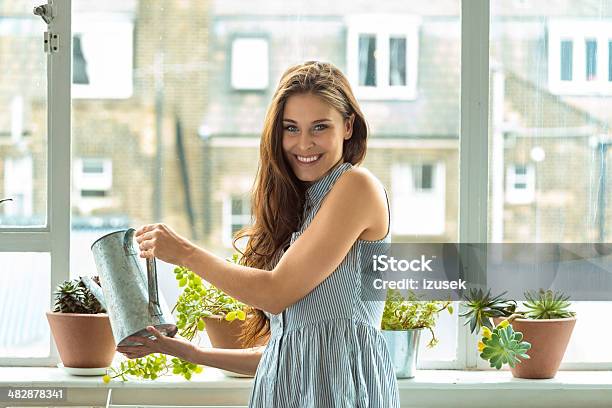 Woman Watering Plants Stock Photo - Download Image Now - One Woman Only, Women, 20-24 Years