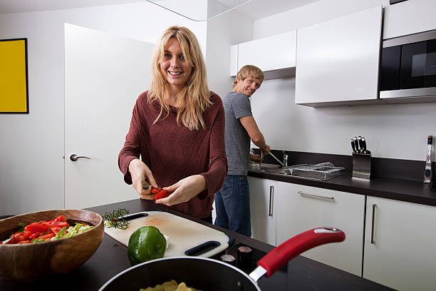 istock Happy woman preparing food with man standing in kitchen 482879441