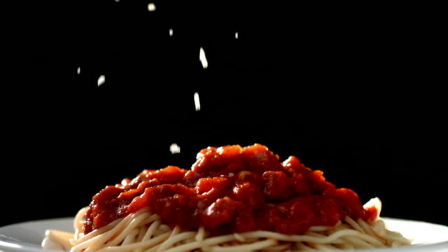 Parmesan cheese falling onto spaghetti, slow motion