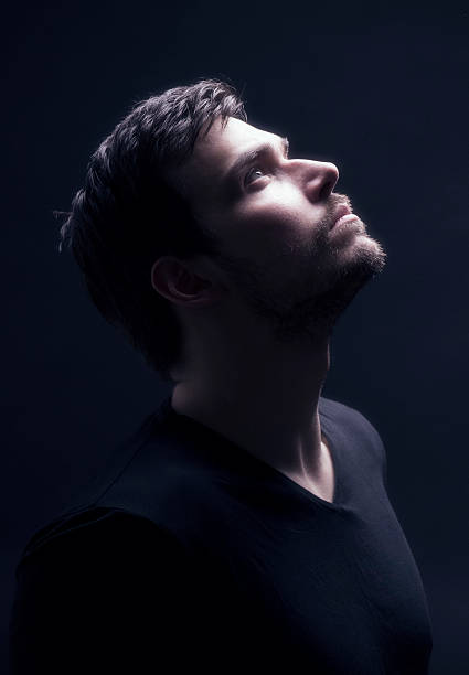 Portrait of a young men looking up, in sci-fi atmosphere. Soft focus intentional.