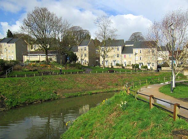 Image of river, pathway, trees and modern townhouses