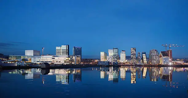 Photo of Skyline of Oslo at night reflecting in water.