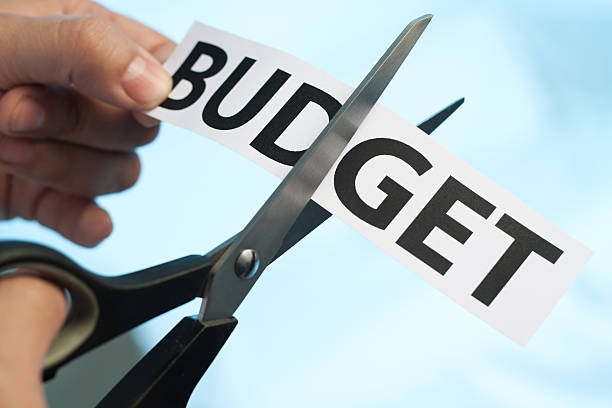 Budget cut Scissors cutting the word "budget" on blue background. You may also like:  budget cut stock pictures, royalty-free photos & images